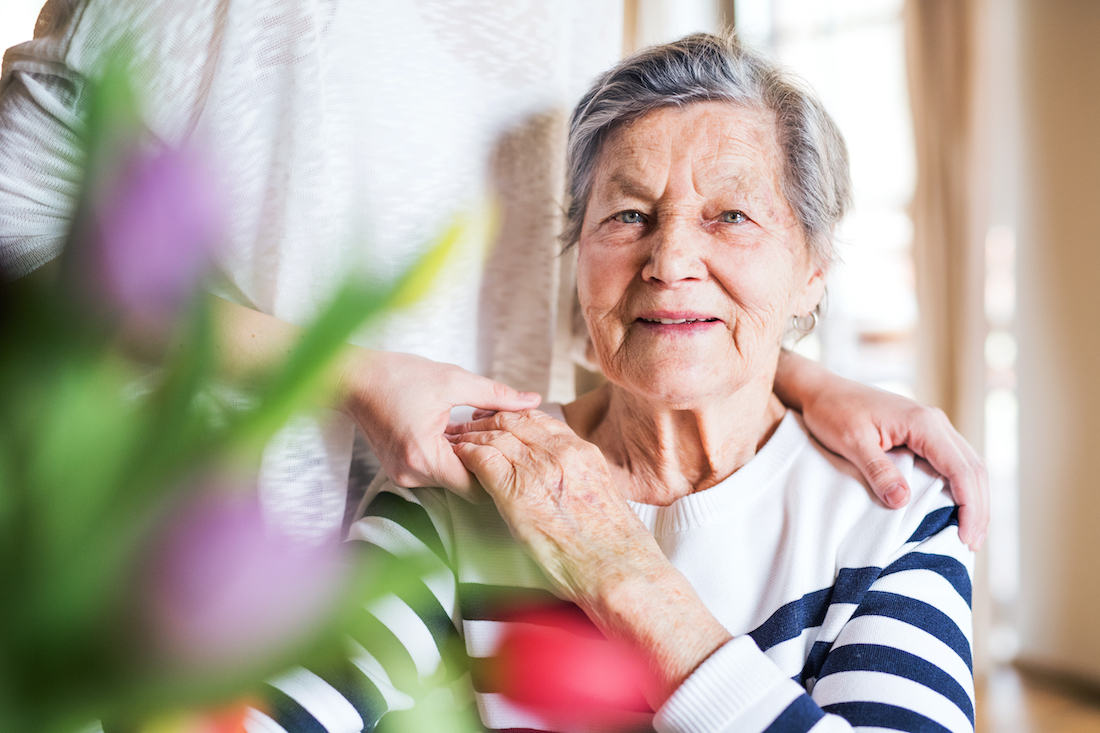 Portrait of an elderly grandmother with a granddaughter at home.