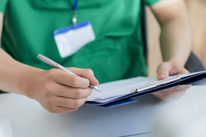 image of doctor filling medical history of patient