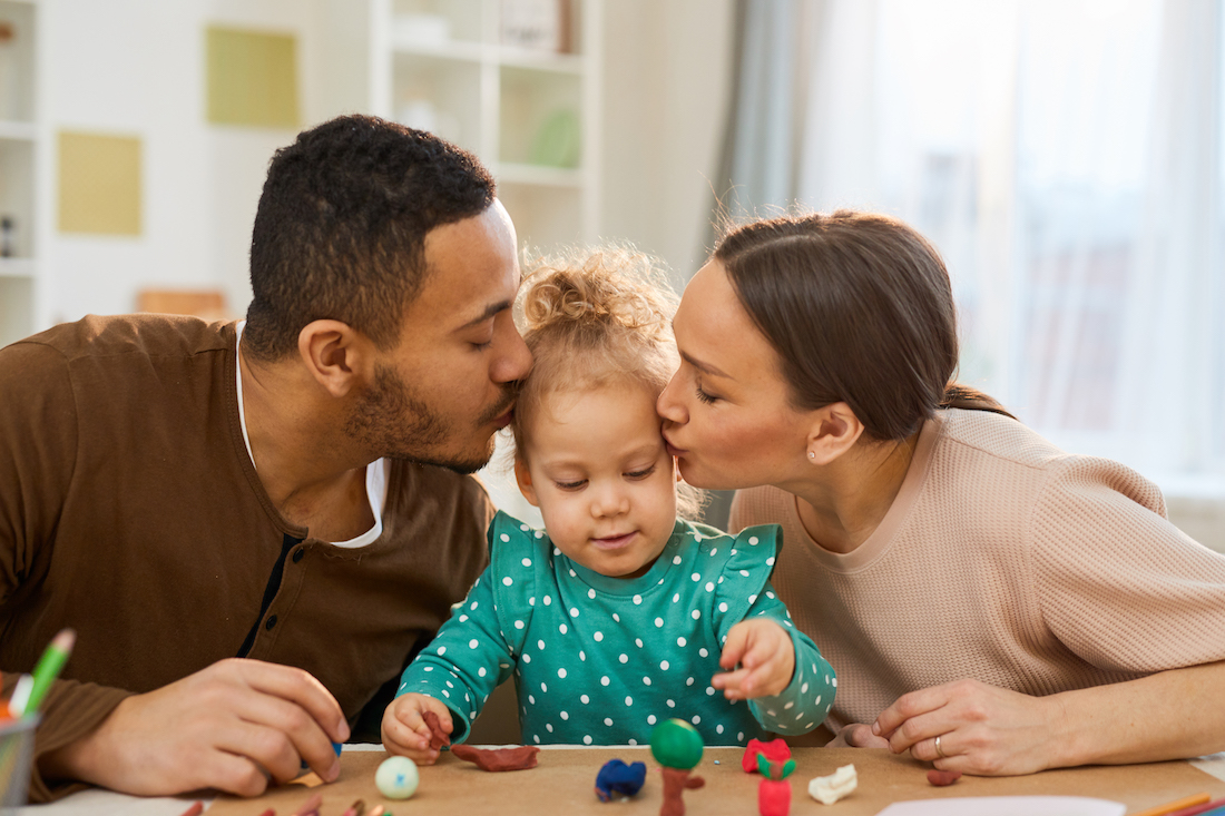 Loving Parents Kissing Child