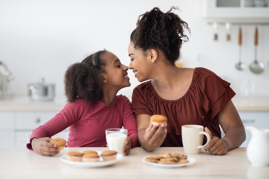 Happy African American mom and daughter enjoying time together at home