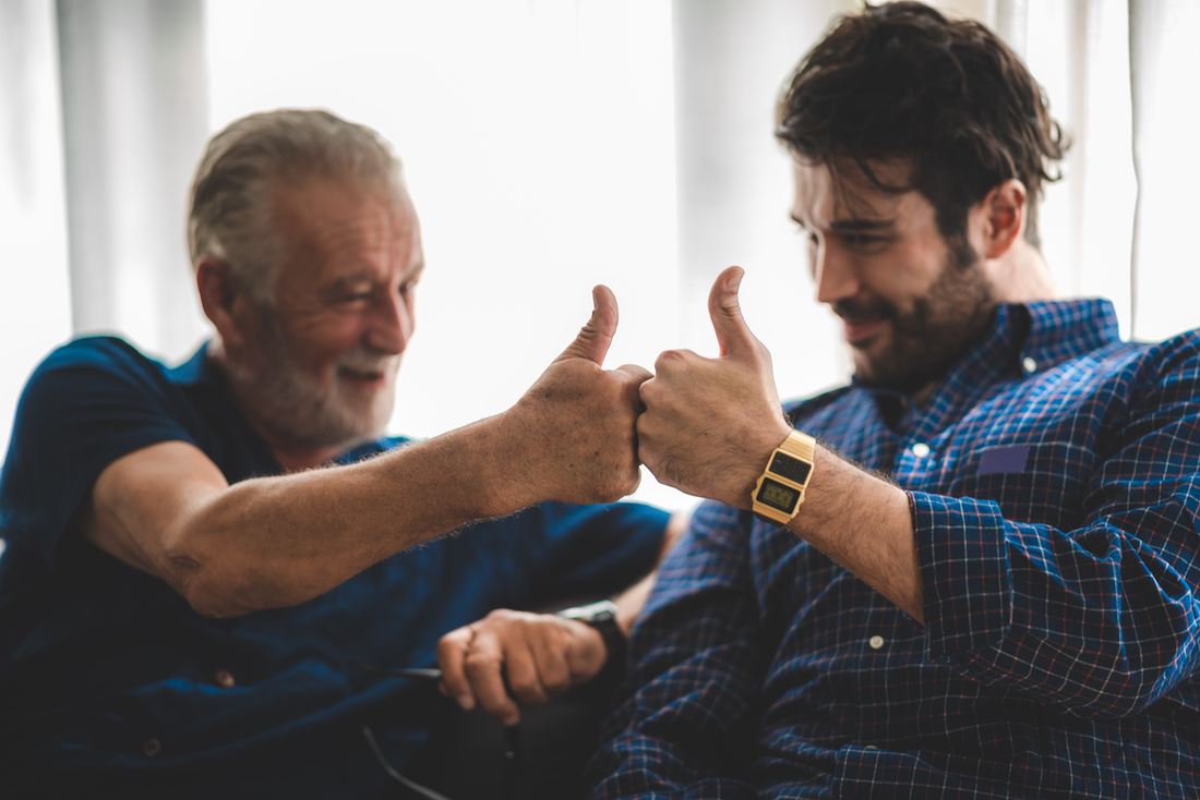 The happy elderly father and son spent time together with smiling, laughing and talking at cozy home garden.