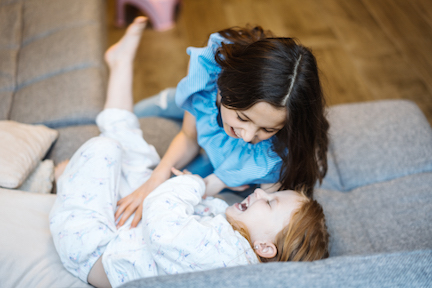 Child support & child custody. two sisters playing together on the big couch