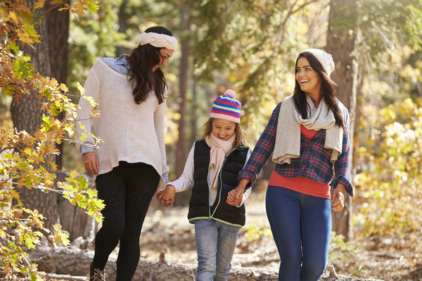 Female parents walking in a forest with daughter