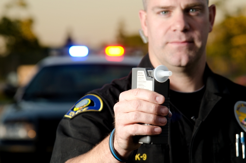 Police officer giving a breathalyzer test