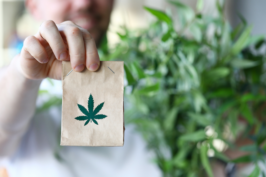 Cannabis business in Minnesota. Man holding paper bag with Marijuana