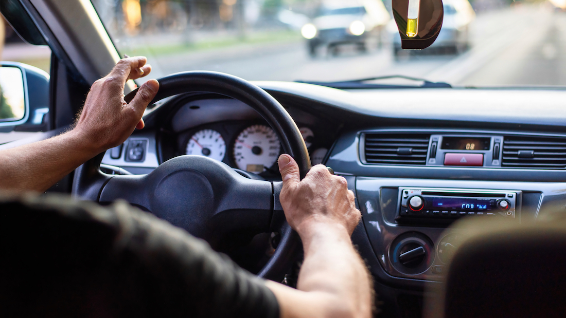 A man driving a car smoking a joint