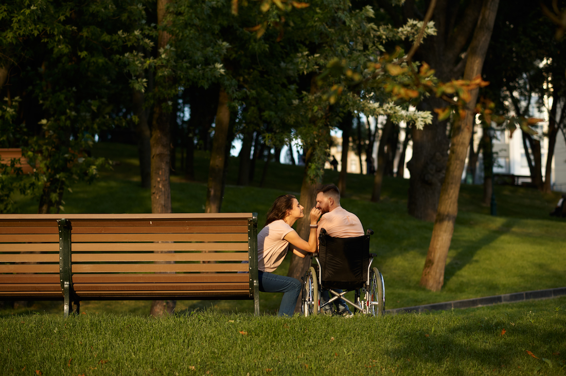 Couple, care for disabled man in wheelchair