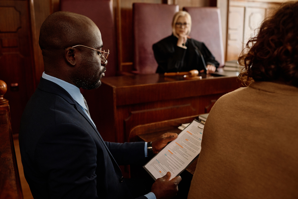 Confident defense attorney in court with client in St Cloud MN for sexual assault hearing