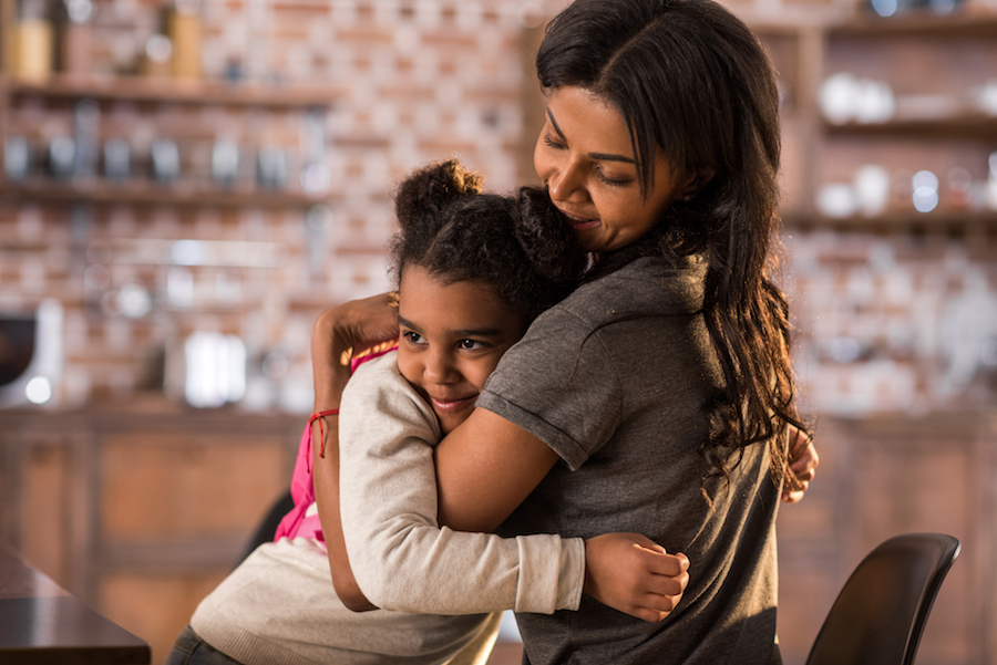 mother hugging daughter protectively